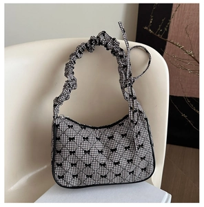 Detail of checkered hobo bag with black bow prints and ruffled cloud-like handle