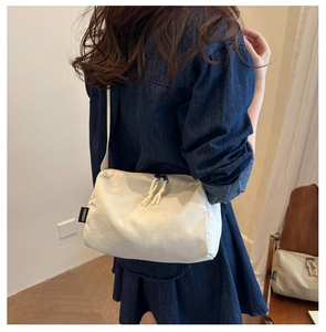 Λεπτομέρεια της off-white πάνινης τσάντας με φερμουάρ-κόμπο σε τζιν φόντο