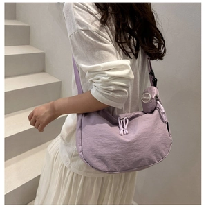 Detail view of light purple crescent shoulder bag with drawstring texture and coin pouch