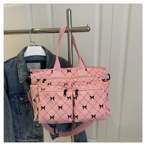 Dettaglio della borsa tote in velluto rosa con ricamo a fiocco e tasche con zip