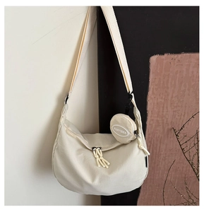 Detail of minimalist nylon crescent bag with matching round coin purse and wide strap
