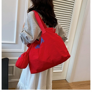 Detail der roten Canvas-Tasche mit Rich Beach Aufdruck und Mini-Kordelzugbeutel
