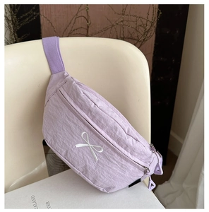 Detail of light purple nylon bag with white bow embroidery and double metal zippers