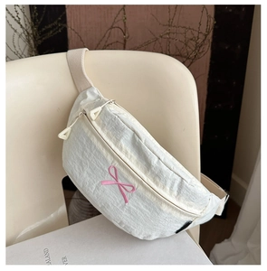 Detail of cream nylon crossbody bag with pink bow embroidery and double zippers