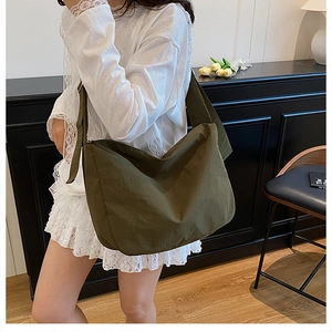 Detailed view of an army green large capacity nylon crossbody bag with wide strap