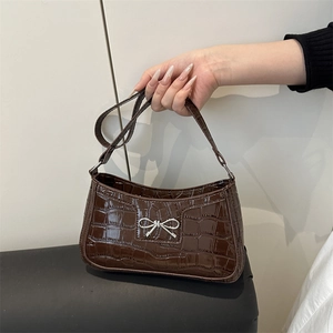 Dark brown faux crocodile leather baguette bag featuring a silver metal bow buckle