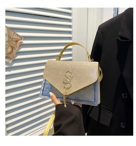 Detail of champagne gold chain bag featuring rhinestone lid and metal letter logo charm
