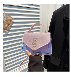 Detail of pink and purple crossbody bag featuring rhinestones and stylish tassel pendant