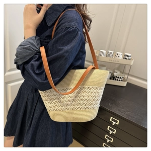 Detail der handgewebten Strohtasche mit filigranen Hohlmustern und braunem Trageriemen