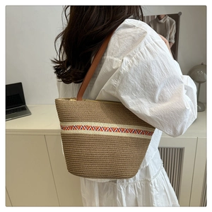 Detailaufnahme der gewebten Beuteltasche mit buntem Geometrieband und Ledergriffen