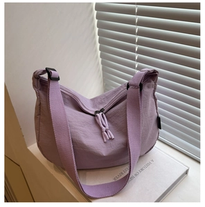Detail of lavender nylon crescent bag showing fabric texture and dual zipper closure