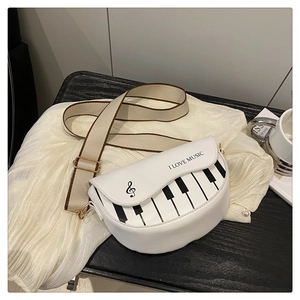 Détail du sac piano blanc avec texte I Love Music et large bandoulière en tissu