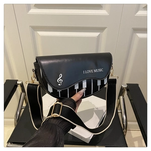 Détail du design de touches de piano sur le sac à bandoulière en cuir noir musical