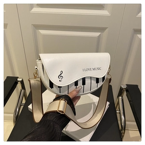 Détail du sac selle blanc avec motif touches de piano et large bandoulière en toile
