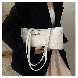 Close-up of beige baguette bag featuring silver buckle detail and glossy PU finish