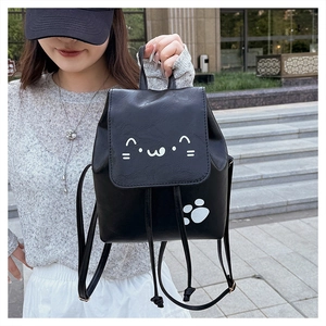 Detail of a mini black PU leather backpack featuring cute white cat face and paw prints