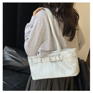 Detail of light blue glossy leather baguette bag with silver buckle and shoulder strap
