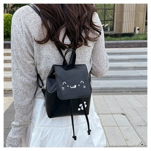 Close-up of black mini leather backpack featuring cute white cat paw and face prints