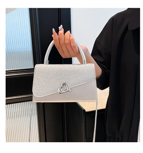 Detail of silver handbag with sequin flap and heart-shaped metal twist lock closure