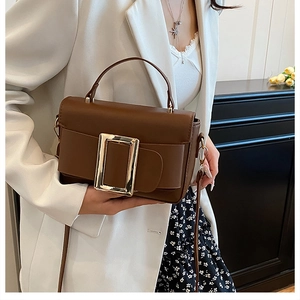 Close-up of brown PU leather handbag with a large gold square buckle on a model