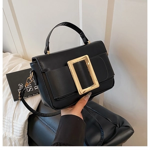 Close-up of black PU leather handbag featuring a prominent gold square buckle and handle