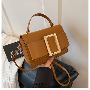 Close-up of brown PU leather crossbody bag featuring a signature gold rectangle buckle