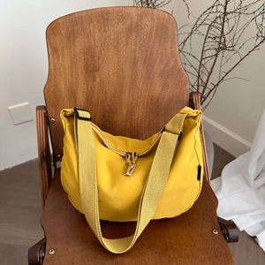 Ginger yellow crescent tote bag on a wooden chair with a minimalist interior background