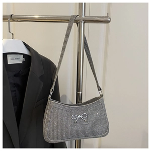 Detailansicht der glitzernden silbernen Strasssteine und Schleife dieser Handtasche