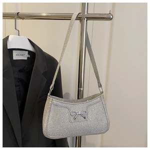 Detail der silbernen Pailletten-Handtasche mit Metallschleife am Display