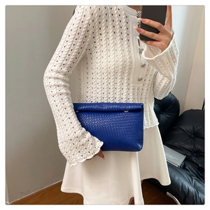 Close-up of royal blue woven leather texture on a stylish minimalist clutch bag