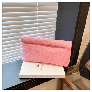 Macro detail of pink woven texture on minimalist handbag with stylish folded edges