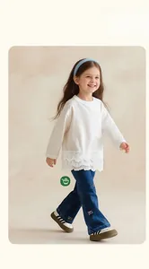 Detail of girls white long sleeve t-shirt with lace hem and butterfly jeans