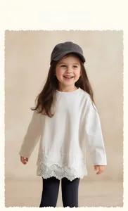 Close-up of girls white cotton top featuring three-layered delicate lace hem detail