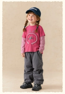 Detail of kids pink long sleeve tee with 3D cartoon cat motif and casual cotton trousers