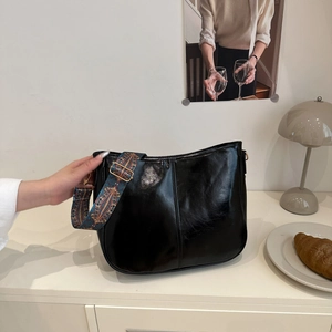 Retro black faux leather hobo tote bag with a colorful bohemian woven shoulder strap
