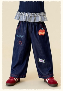Detail of kids denim pants featuring colorful cartoon embroidery and red contrast stitching