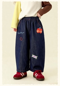 Close-up of children's denim pants with apple patch and Thankyou embroidery detail