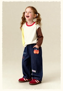 Detail of kids patchwork long sleeve t-shirt and loose denim jeans with embroidery