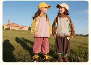 Detail of kids outdoor color-block windproof jackets and pants in a scenic park