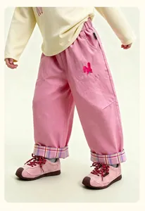 Detail of pink girls' trousers with cartoon rabbit patch and checkered cuff design