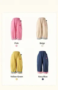 Detail of four colorful kids casual trousers featuring plaid cuffs and rabbit embroidery