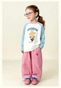 Close-up of pink trousers with cute bunny embroidery and plaid lining cuff details