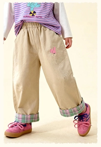 Detail of beige kids' trousers featuring a cute rabbit embroidery and plaid hem cuffs