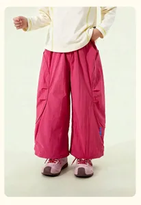 Detail of kids casual wide-leg pants in vibrant pink featuring stylish side lettering print
