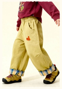 Detail of kids casual trousers with rabbit embroidery and plaid hem lining