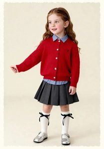 Full view of girl's British style outfit with red knit cardigan and pleated skirt