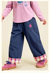 Detail of navy cotton kids trousers with pink rabbit embroidery and plaid hem lining