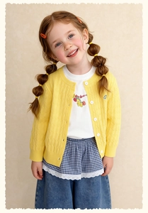 Detail of yellow knit cardigan with embroidered letter a and lace denim jeans