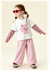 Detail of child's pink cotton wide-leg trousers paired with a plaid shirt and white tee