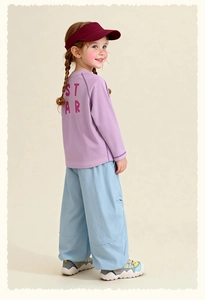 Detail view of kids lavender long sleeve tee with red STAR print and light blue wide trousers